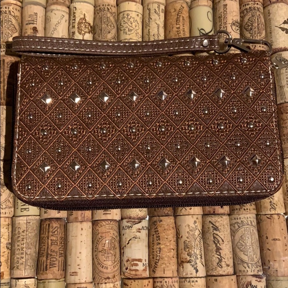 Embroidered and studded vegan leather wristlet.